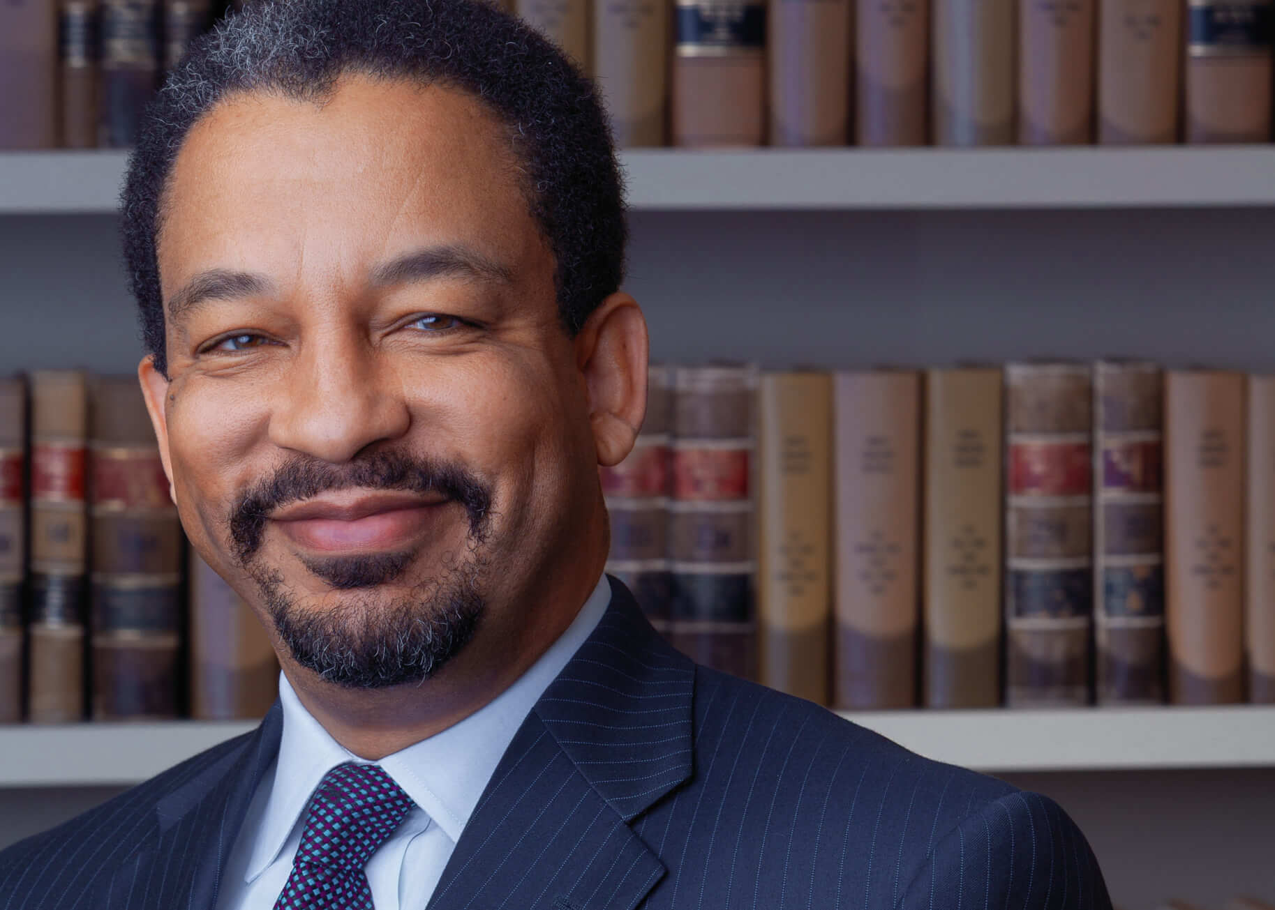 A headshot of an Attorney in their office with