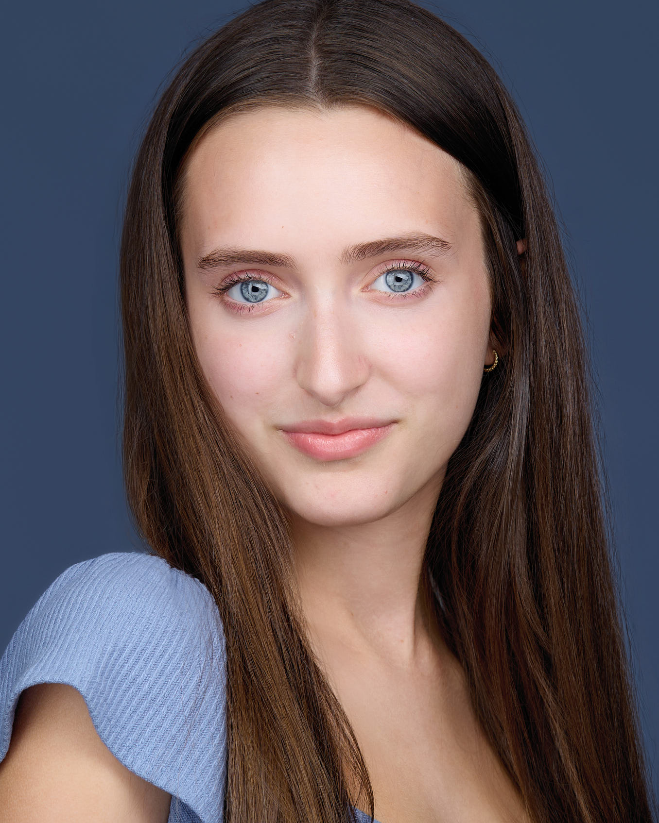 Young girl acting headshot on a blue backdrop