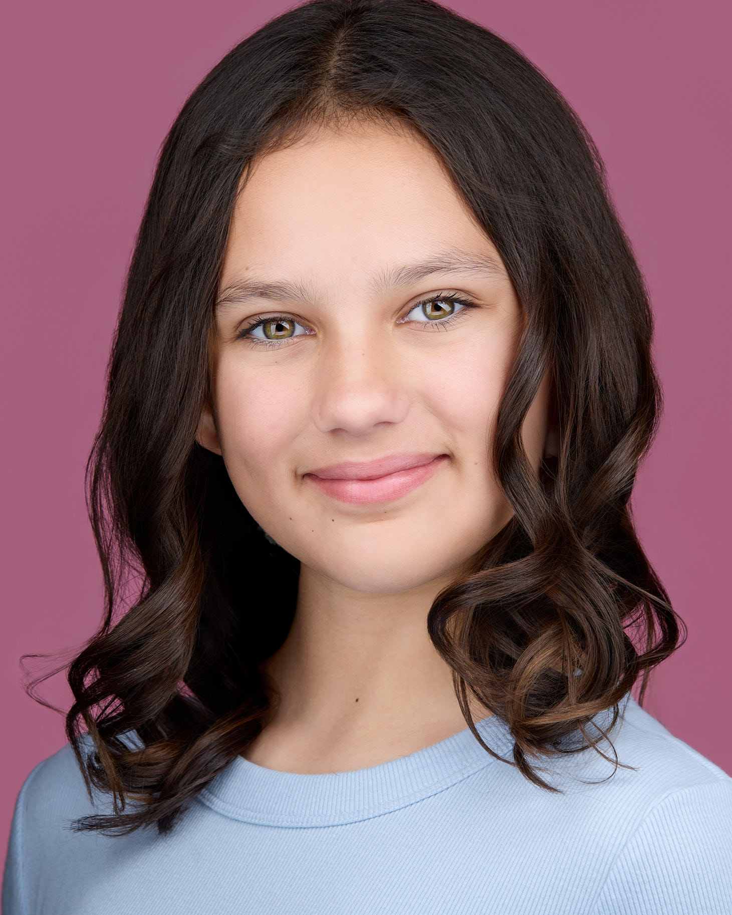 Young girl acting headshot on a pink backdrop