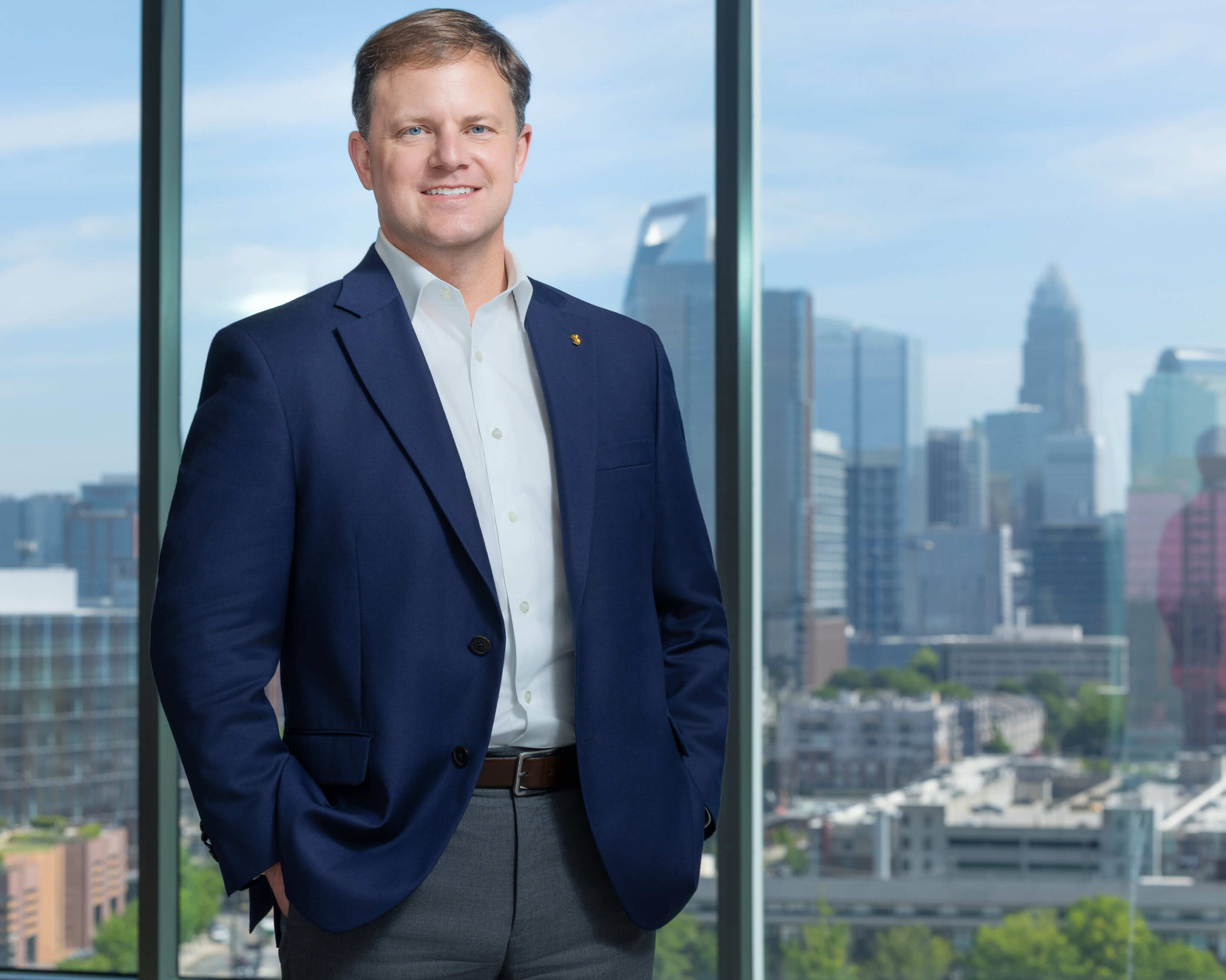 SouthState Bank Corporate Executive Headshot – Charlotte NC Photography A male executive in a suit smiling with the Charlotte city skyline in the background.