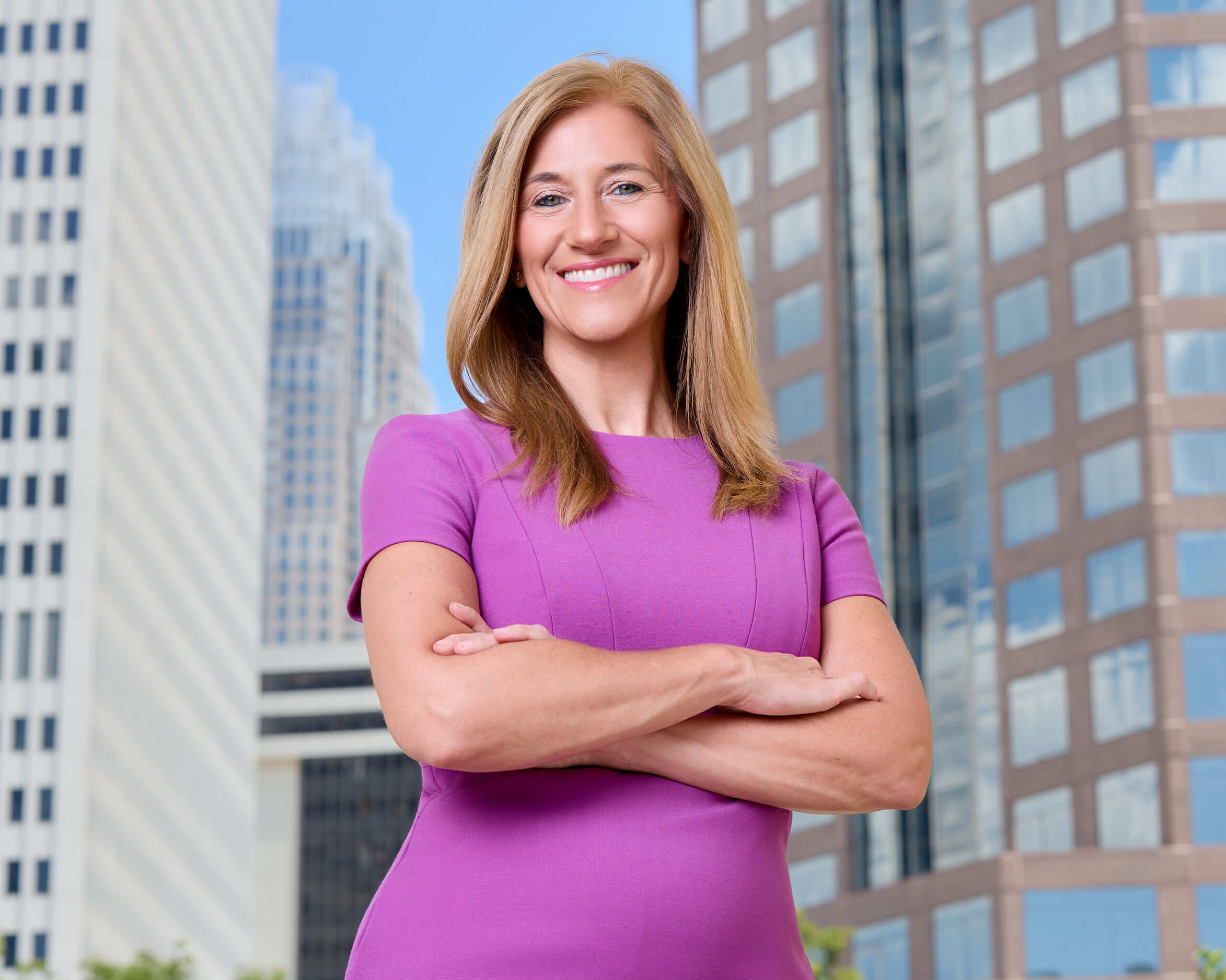 Stroupe.A-headshot-charlotte-fenixfoto-AT020462 - 0 - 12 A lawyer standing in downtown Charlotte, with the skyline as a background for her portriat